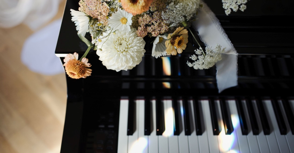 wild flower arrangement set atop a piano with rainbow light flares